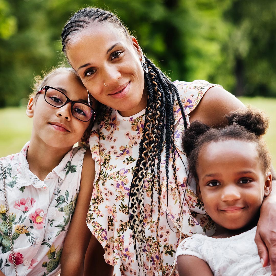 Portrait of a mother and her two daughters outdoors