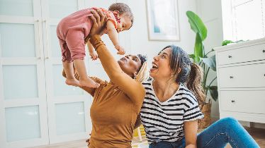 Photo of a couple playing with their baby