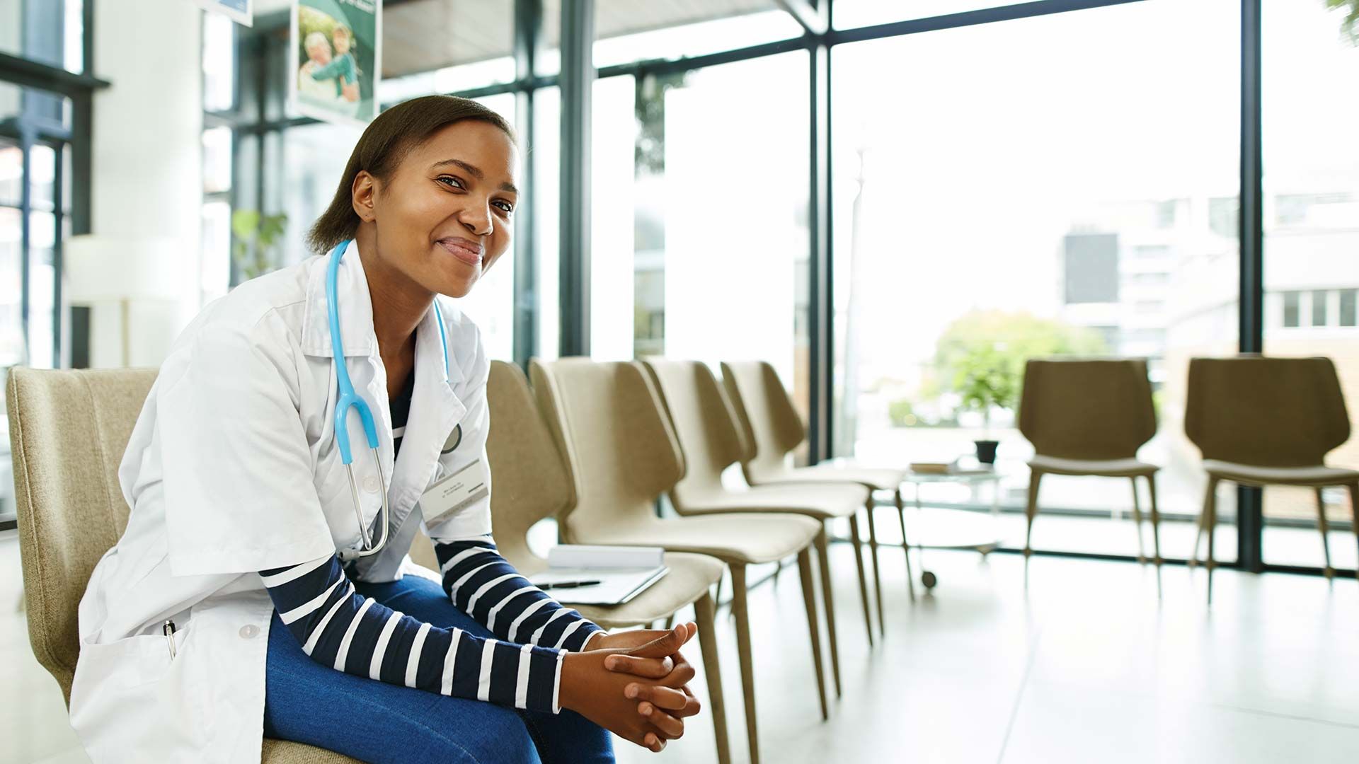smiling doctor sitting in hospital waiting room