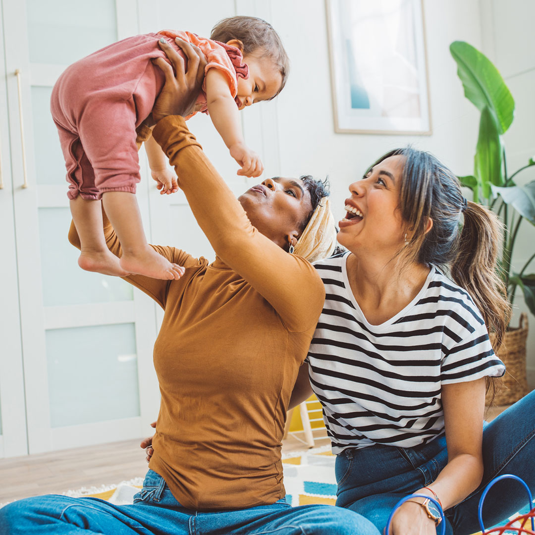 Photo of a couple playing with their baby