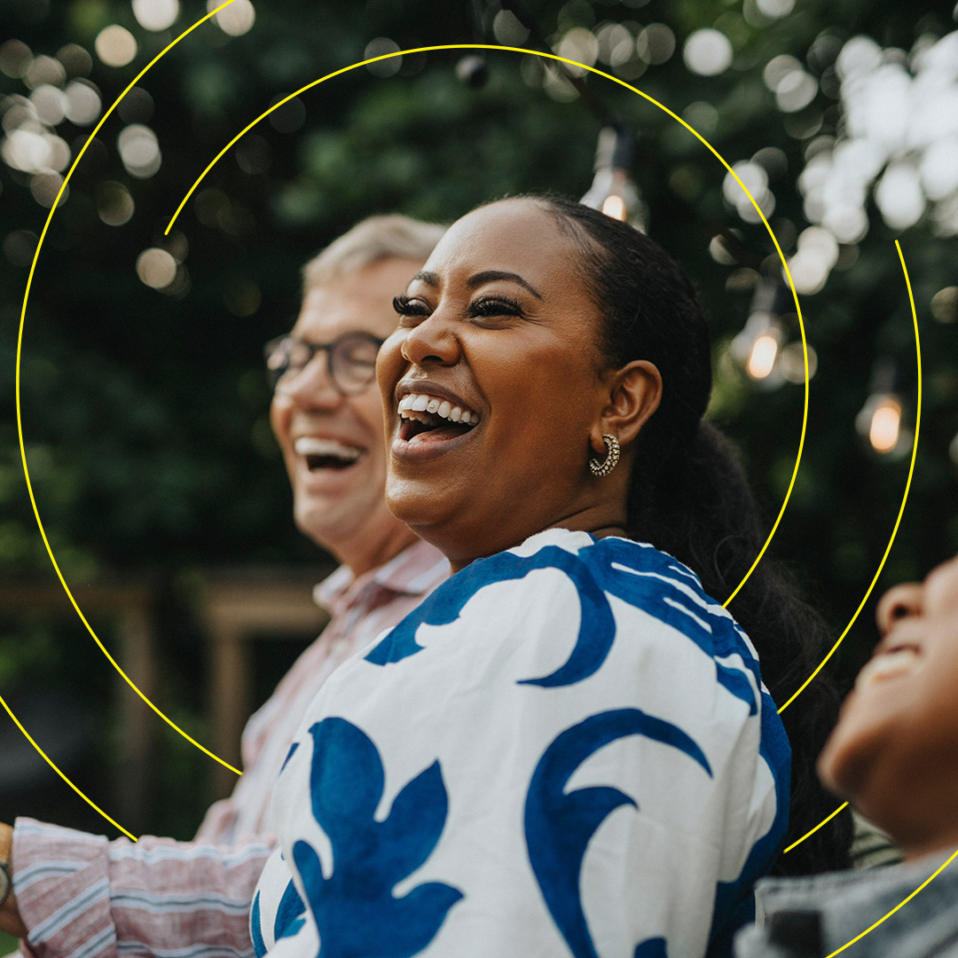 A woman expresses joy at an outdoor gathering of family and friends