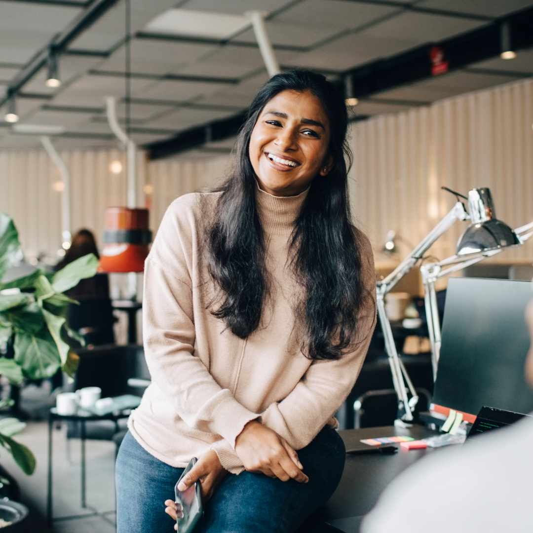 Woman holding papers working on her computer