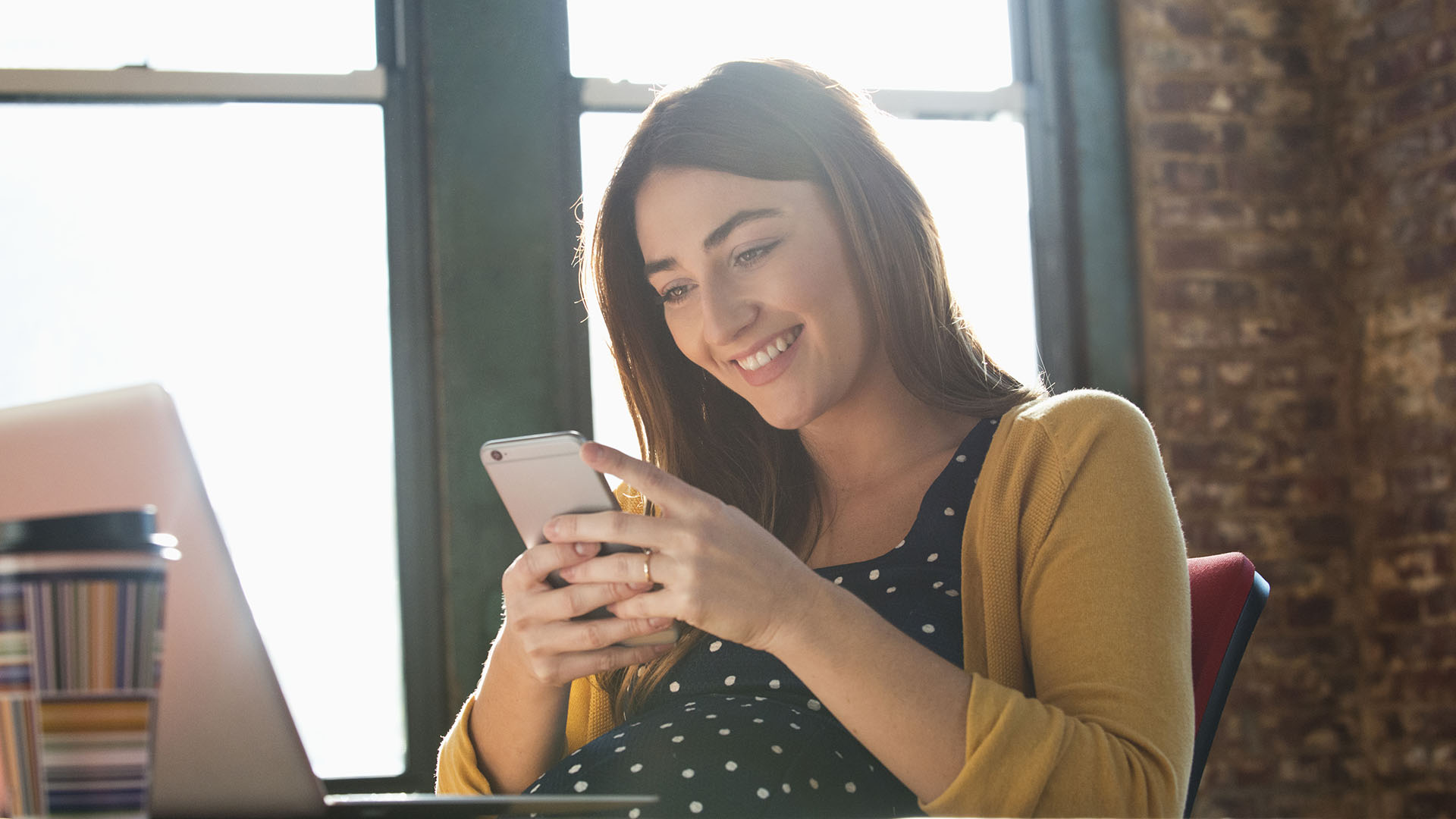 Woman using her phone to access her company's employee wellbeing platform