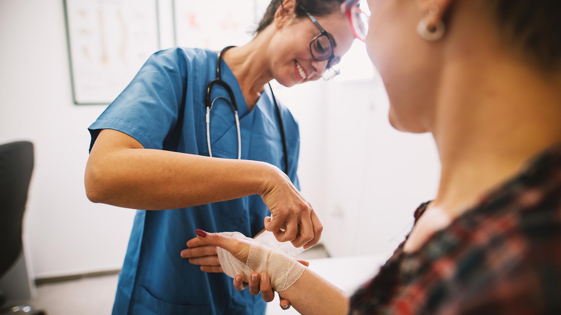 doctor wrapping patients sprained wrist