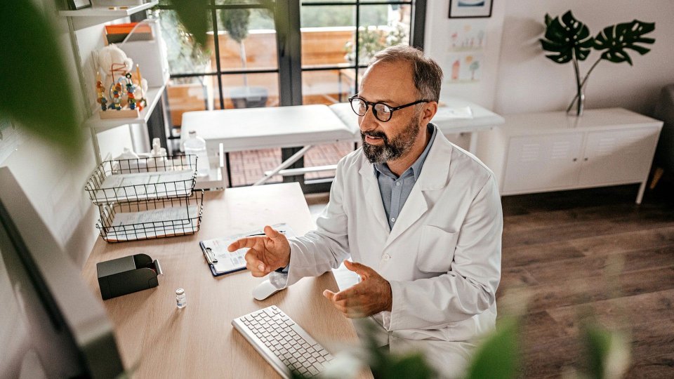 Medical professional having a virtual meeting at his desk.