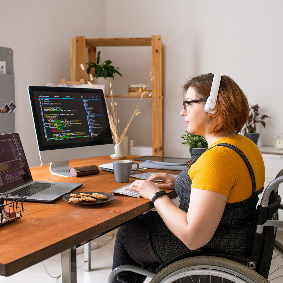 Woman wearing headphones works on a computer in her home office