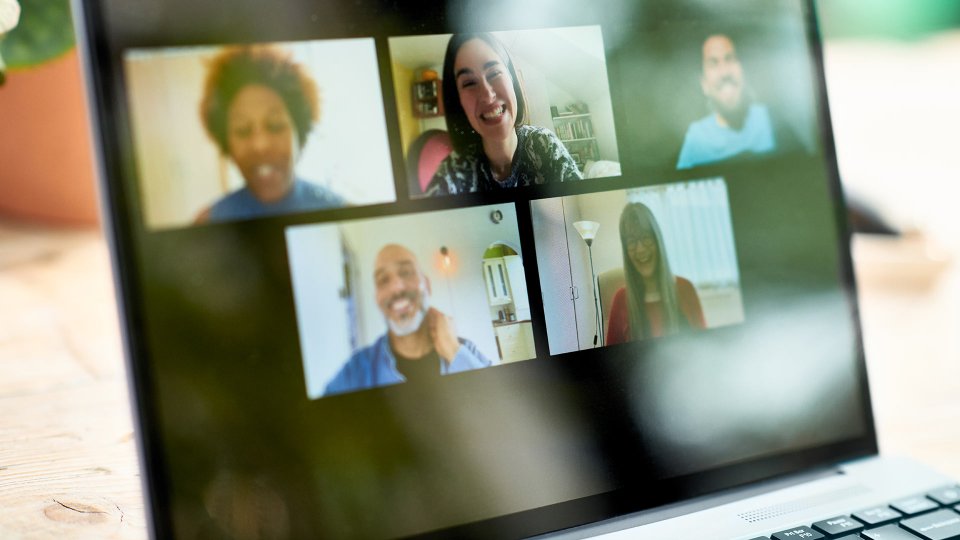 Laptop screen showing a team of remote employees on a video conference call
