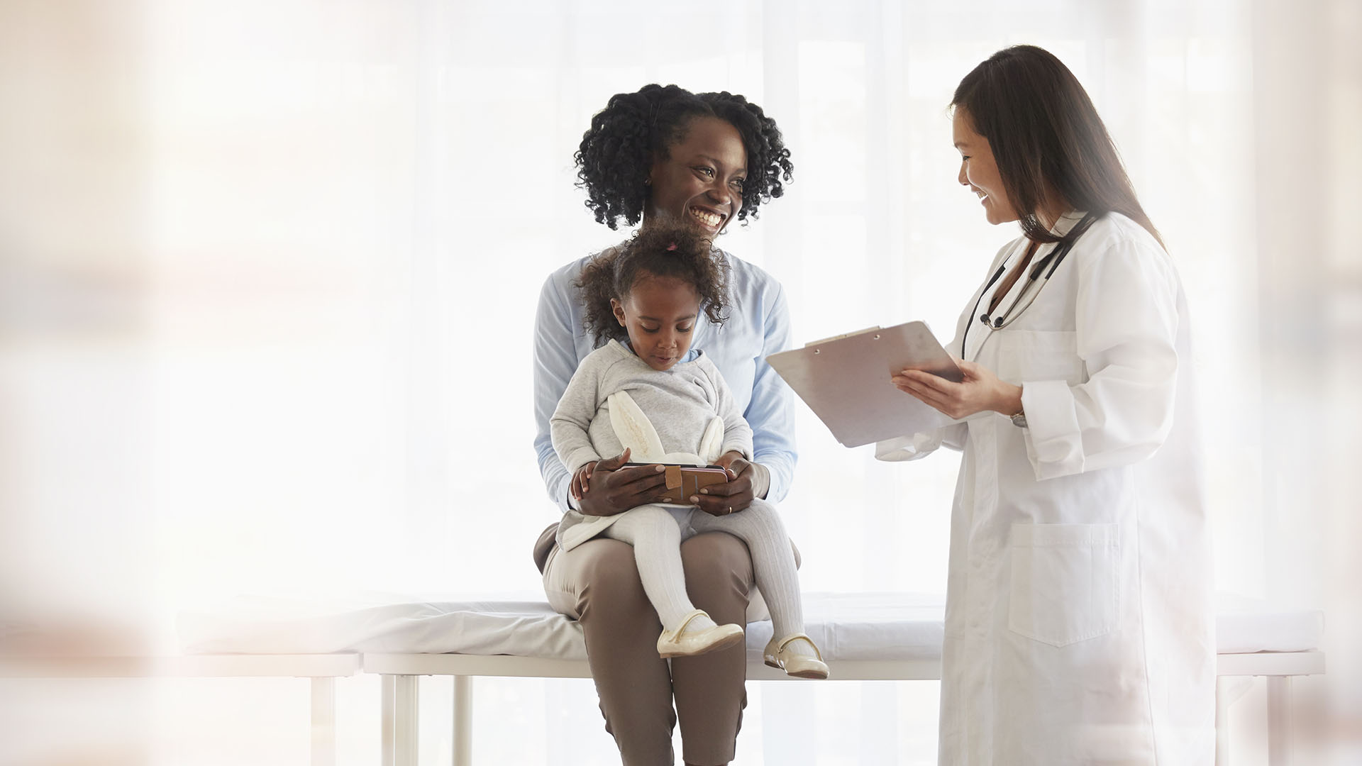 smiling toddler and parent at doctors appointment