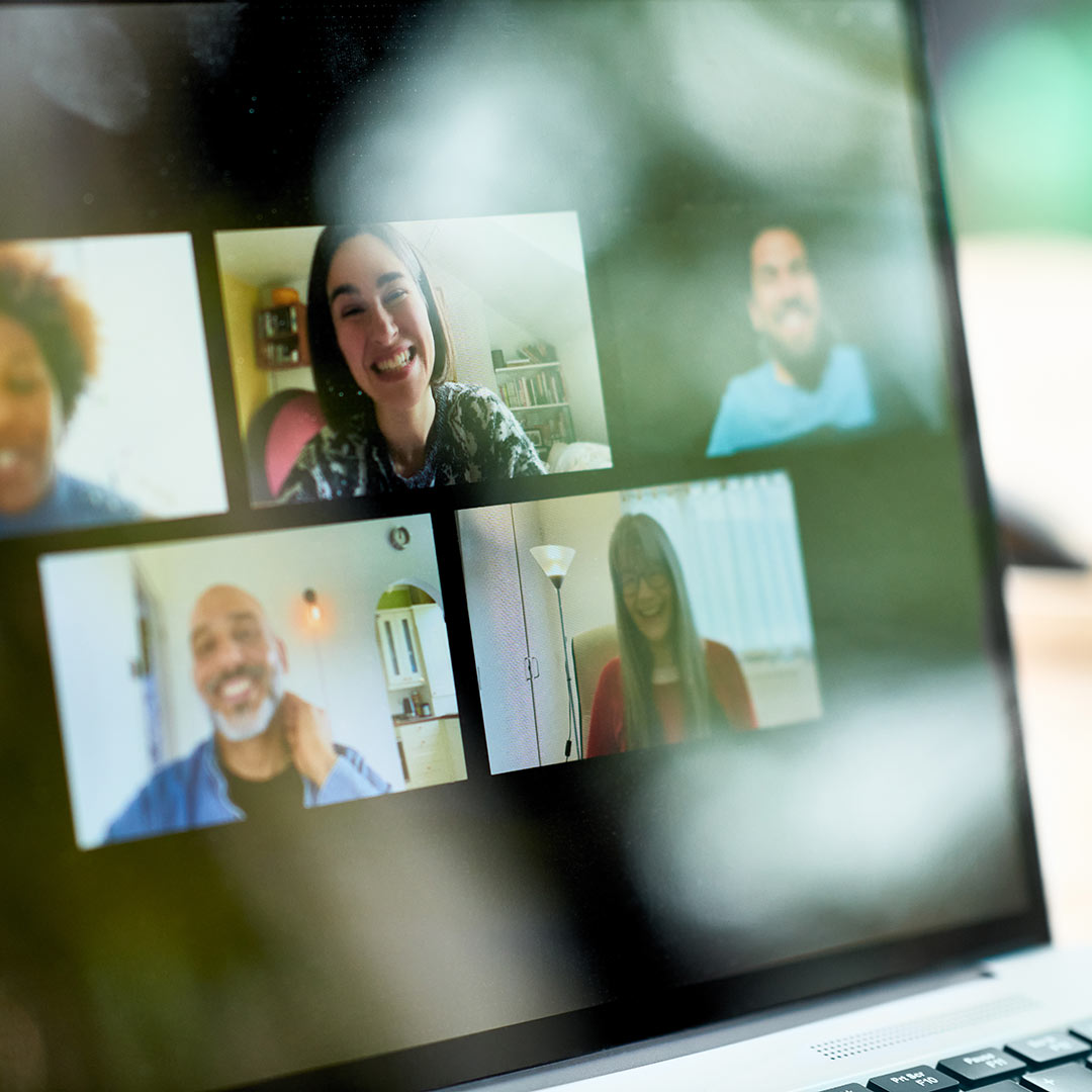 Laptop screen showing a team of remote employees on a video conference call
