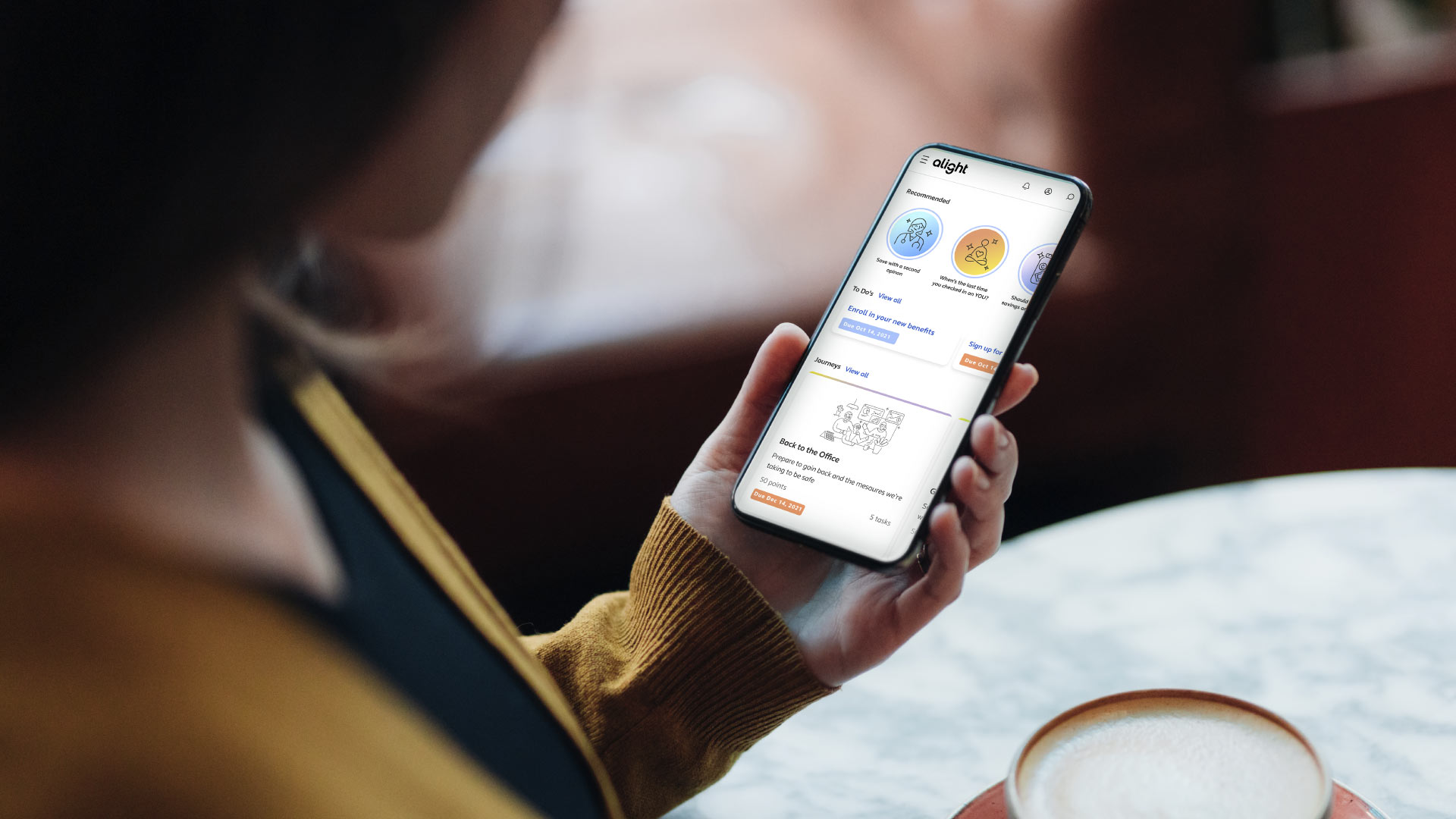 hand holding a phone that is displaying a page from the Worklife app