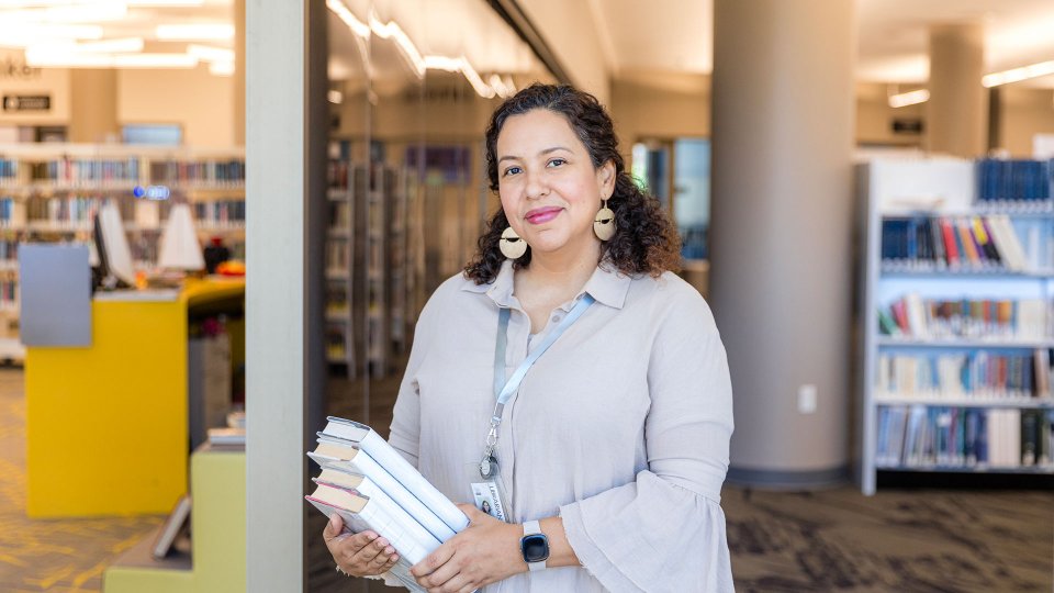 Librarian holding a stack of books