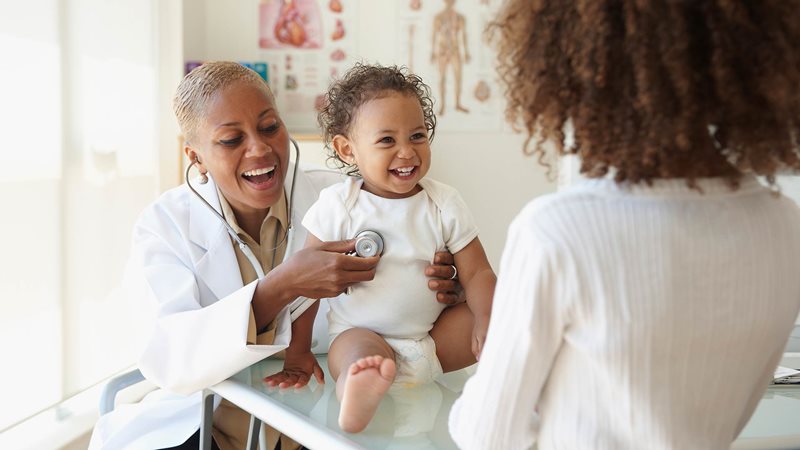 smiling toddler and parent at doctors appointment